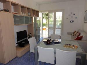- un salon avec une table, des chaises et une télévision dans l'établissement House and Apt in Bibione 38402, à Bibione