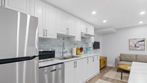 a kitchen with white cabinets and a white refrigerator at Family Friendly - Cozy - HOT TUB - Near UOIT in Oshawa