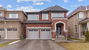 a brick house with two garages at Family Friendly - Cozy - HOT TUB - Near UOIT in Oshawa