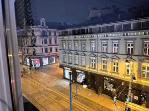 vistas a una calle de la ciudad por la noche con edificios en City Center Apartment, en Katowice