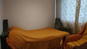 a small bedroom with a bed with an orange blanket at Квартиры in Izyum