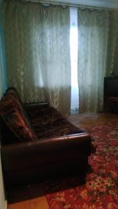 um sofá numa sala de estar com uma janela em Квартиры em Izyum