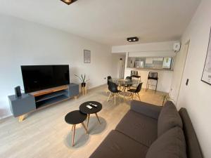 a living room with a couch and a table at Departamento céntrico a estrenar - Con piscina y parking incluido in Tigre