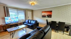 a living room with a couch and a dining room at 5 min walk to City Center in Toowoomba