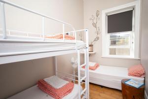 艾略特港的住宿－YHA Port Elliot Beach House，小型客房设有两张双层床和窗户。
