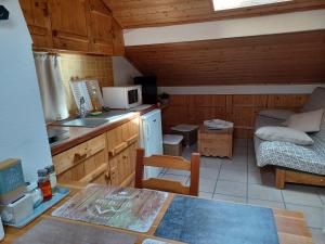 a small kitchen with a table and a microwave at STUDIO LE MONT-CENIS, GARAGE pour motards et cyclistes, gare a 800m in Fourneaux