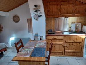 a kitchen with a wooden table with chairs and a sink at STUDIO LE MONT-CENIS, GARAGE pour motards et cyclistes, gare a 800m in Fourneaux