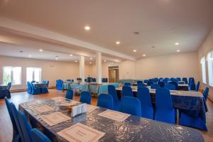 a banquet hall with blue tables and blue chairs at Cavendish Memotree Resort in Cavendish