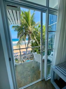 Cette chambre dispose d'un balcon avec vue sur la plage. dans l'établissement Smeralda Beach Hotel Dikwella, à Dikwella