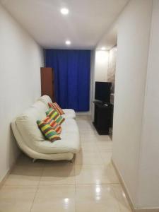 a living room with a white couch with colorful pillows at Funza Apartamento Normandia del Parque II in Funza