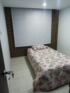a bedroom with a bed in front of a window at Funza Apartamento Normandia del Parque II in Funza