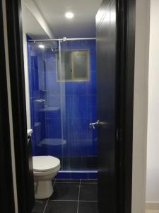 a bathroom with a toilet and a blue shower at Funza Apartamento Normandia del Parque II in Funza