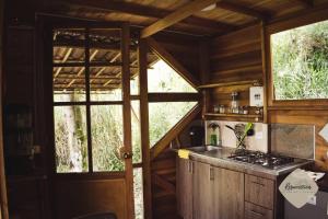 聖法蘭西斯科的住宿－Cabaña Resurrección，小屋内的厨房设有炉灶和窗户。
