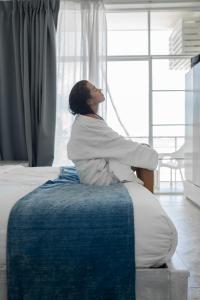 une femme assise au bord d'un lit dans l'établissement Smeralda Beach Hotel Dikwella, à Dikwella