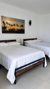 2 camas en una habitación con palmeras en la pared en Red Flamboyan Guesthouse and Restaurant, en Rincón