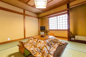 una camera con un letto, un tavolo e una finestra di Oyado Hisaya a Kami