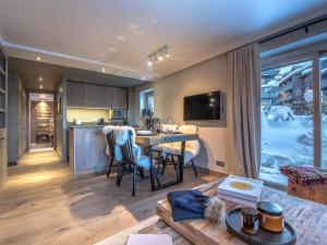 a kitchen and living room with a table and chairs at Appartement Neuf et Luxueux Centre Courchevel 1850, Proche Pistes et Services - FR-1-575-160 in Courchevel +5 photos