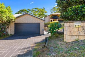un garage avec une porte sur le côté d'une maison dans l'établissement Trumpeter, à Corlette