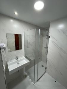 a white bathroom with a sink and a shower at Hotel Bradomin in Villanueva de Arosa