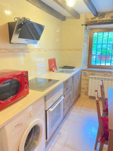 a kitchen with a washing machine and a microwave at Vivienda Vacacional Trespandiu in Oceño
