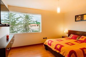a bedroom with a bed and a large window at Cayma, Amplio y elegante Dpto. muy bien ubicado in Arequipa