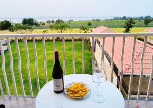 uma garrafa de vinho e uma taça de batatas fritas numa mesa em Isola Luxury Farm Suites em Nashik