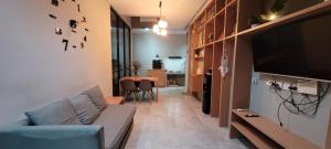 a living room with a couch and a flat screen tv at Haidar SmartHome Grandwisata in Cibuntu