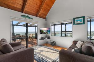 uma sala de estar com dois sofás e vista para o oceano em Simply Fabulous - Mangawhai Heads Holiday Home em Mangawhai