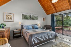 um quarto com uma cama e uma janela em Simply Fabulous - Mangawhai Heads Holiday Home em Mangawhai