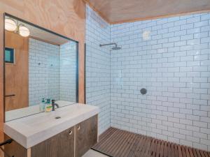 a bathroom with a sink and a shower at The Pumpkin Shed - Kuaotunu Holiday Home in Kuaotunu +16 photos