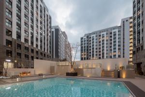 una piscina en una ciudad con edificios altos en Chestertons Sokcho en Sokcho