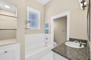 a white bathroom with a sink and a bath tub at Shore Fun At Destin Pointe Resort in Destin +33 photos