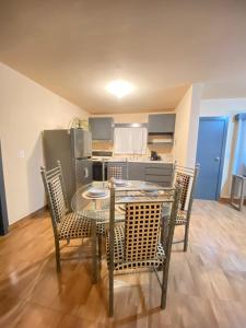 a dining room with a table and chairs and a kitchen at Departamento familiar en Ensenada in Ensenada