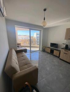 un soggiorno con divano e una grande finestra di Modern 1 bedroom apartment 400m away from the sea a San Pawl il-Baħar