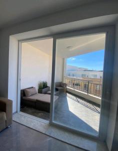 un soggiorno con divano e una grande finestra di Modern 1 bedroom apartment 400m away from the sea a San Pawl il-Baħar