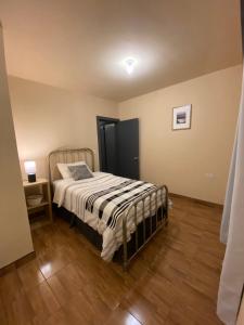 a bedroom with a bed and a wooden floor at Departamento familiar en Ensenada in Ensenada