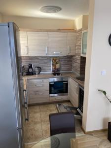 uma cozinha com armários de madeira e um frigorífico em Luxury family apartament em Burgas