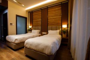 Sangam City Hotel Pure Veg في كاتماندو: سريرين في غرفة الفندق مع نوافذ