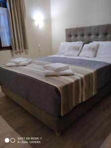 Menelaos Apartments في ليفوكاسترو: سرير عليه وسادتين في غرفة