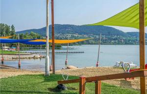 a beach with umbrellas and a body of water at Pihi Vendégház in Badacsonytomaj