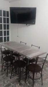 a large table with chairs and a television on a wall at Departamentos La Angosta in Acapulco