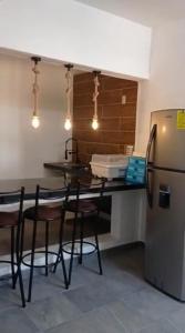 a kitchen with a table and chairs and a refrigerator at Departamentos La Angosta in Acapulco