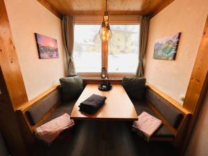 a dining room with a table and a window at Wellness-Apartment Seefeld and Chill SPA im Zentrum mit Pool, Sauna und Netflix for free in Seefeld in Tirol
