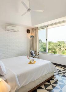 1 dormitorio con cama y ventana grande en 2Bed Stylish Home w Rooftop Pool nr Candolim Beach en Nerul