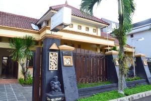 a house with a gate and a statue in front of it at Roemah Canting Homestay in Yogyakarta