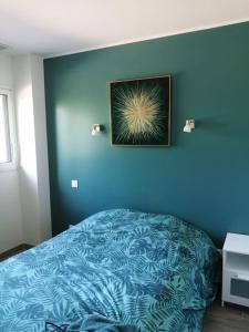 ein blaues Schlafzimmer mit einem Bett und einem Bild an der Wand in der Unterkunft TRES BELLE VILLA CONTEMPORAINE in Causse-de-la-Selle