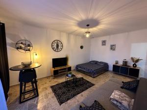 um quarto com uma cama, uma mesa e um relógio em Studio bord de mer em San-Nicolao