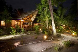 ein Haus mit Lichtern in der Nacht davor in der Unterkunft Metita Beach & Dive Resort in Doruba