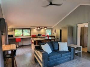 a living room with a blue couch and a kitchen at Cosy Corner in Kampersrus AH