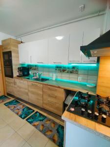 a kitchen with white cabinets and a blue counter top at Lake view luxury apartment in Bucharest
